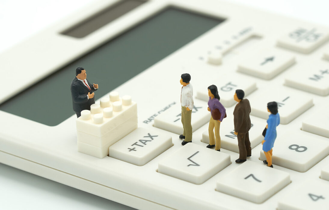 Bild zeigt Miniaturfiguren auf einem Taschenrechner, stellvertretend für uns Steuerzahlende. Mehrere kantonale und kommunale Abstimmungen sowie die Lancierung einer Volksinitiative machen deutlich, dass nicht nur die Besteuerung von Unternehmen, sondern auch die Besteuerung von natürlichen Personen gepflegt werden muss.