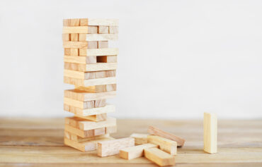13.AHV-Finanzierung-ohne-notwendige-Strukturreform. Abgebildet ist ein Jenga-Holzturm, dessen Fundament schon etliche Schwächen zeigt.