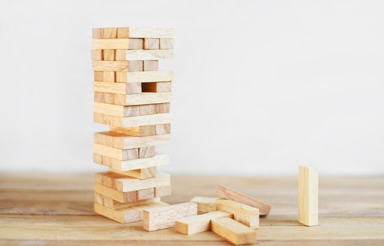 13.AHV-Finanzierung-ohne-notwendige-Strukturreform. Abgebildet ist ein Jenga-Holzturm, dessen Fundament schon etliche Schwächen zeigt.