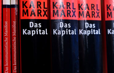 Erbschaftsinitiative: missraten, klassenkaempferisch und kontraproduktiv. Das Buch "Das Kapital" von Karl Marx steht in einem Bücherregal, Buchrücken zum Betrachter zugewandt.