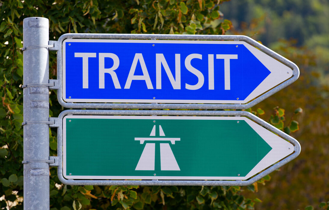 Tranistverkehr: mit Kanonen auf Spatzen schiessen. Im Bild sind ein "Transit" und ein "Autobahn" Wegweiser zu sehen.