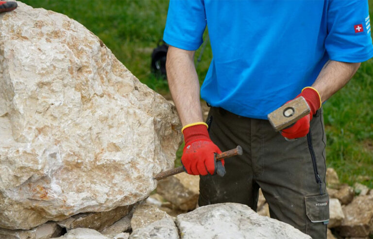 Zivildienst-JA-zu-angemessenen-Anpassungen. Ein Zivildienstleistender im Einsatz bei einer Trockensteinmauer.